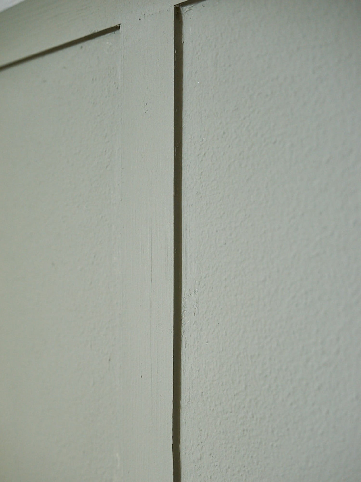Po nanosu barve še bližnji pogled na steno, obloženo z letvicami.