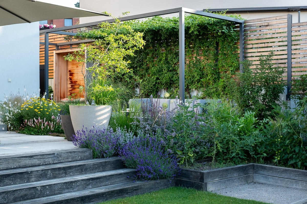 Trajnice in zelenjava lahko sobivajo na istem prostoru. Veliko drevo v loncu doda vertikalnost, zato ni občutka preobremenjenosti prostora.