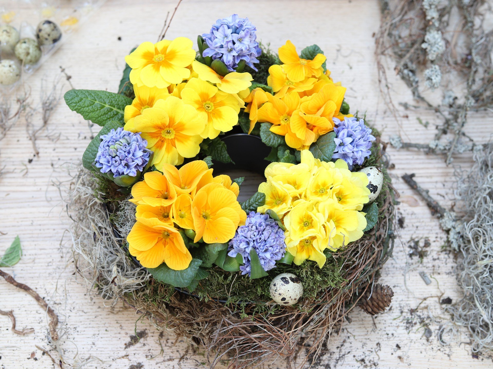 Barvit namizni venec iz spomladanskih rastlin.